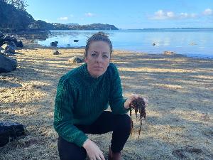 Northland Regional Councillor Amy Macdonald with the red seaweed she discovered at Tamaterau recently.