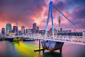 Auckland's vibrant cityscape at sunset, featuring the iconic Sky Tower and striking waterfront architecture.