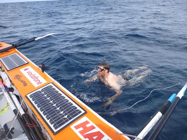 Nigel Cherrie prepares to dive under the Moana to clean the hull on day 16 of Team Gallagher's row from Auckland to New Zealand. 