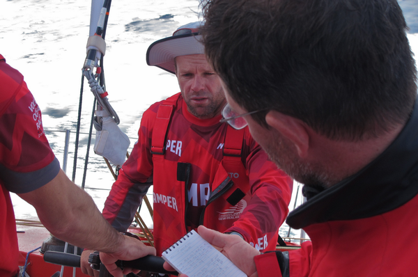 Skipper Chris Nicholson is briefed on the latest position report.