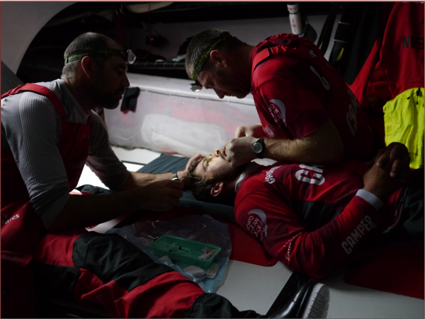 Crew medic Tony Rae sutures Mike Pammenter's severed lip