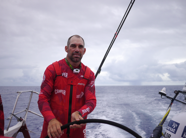 Stu Bannatyne driving in the doldrums with a rain squall behind him.