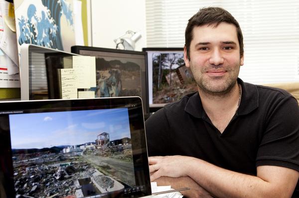  Chris Gomez, with some of the images from his visit to Japan after the 2011 tsunami disaster.