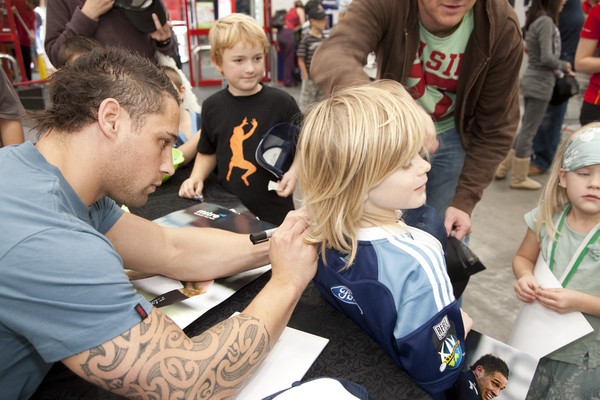 international rugby star Luke McAlister, With Harrison Eakin, 8, at The Warehouse, Albany where he met with fans to say hi and autograph Mitre caps and shoes.