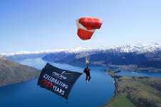 An NZONE instructor flying the birthday flag high above Queenstown