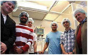 Students (from left) Kirill Makarov, Utsav Patel, Travers Biddle, Thomas Poupouare and Andrew Webb with Peter Norden wearing anti-static clean room headgear in a lab with a model of KiwiSAT at Massey's Albany campus.