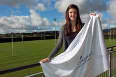 Natalie Paterson holds a Massey University flag featuring messages of support from University staff members.