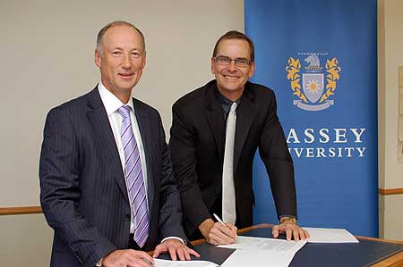 KPMG executive chair Ross Buckley and head of Massey University's College of Business Professor Ted Zorn, signing a research partnership agreement.